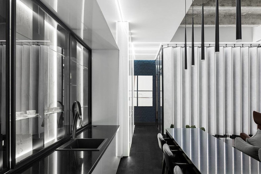 Стильный дизайн: большая прямая кухня-гостиная в современном стиле с одинарной мойкой, черной техникой, темным паркетным полом, островом и черным полом - последний тренд