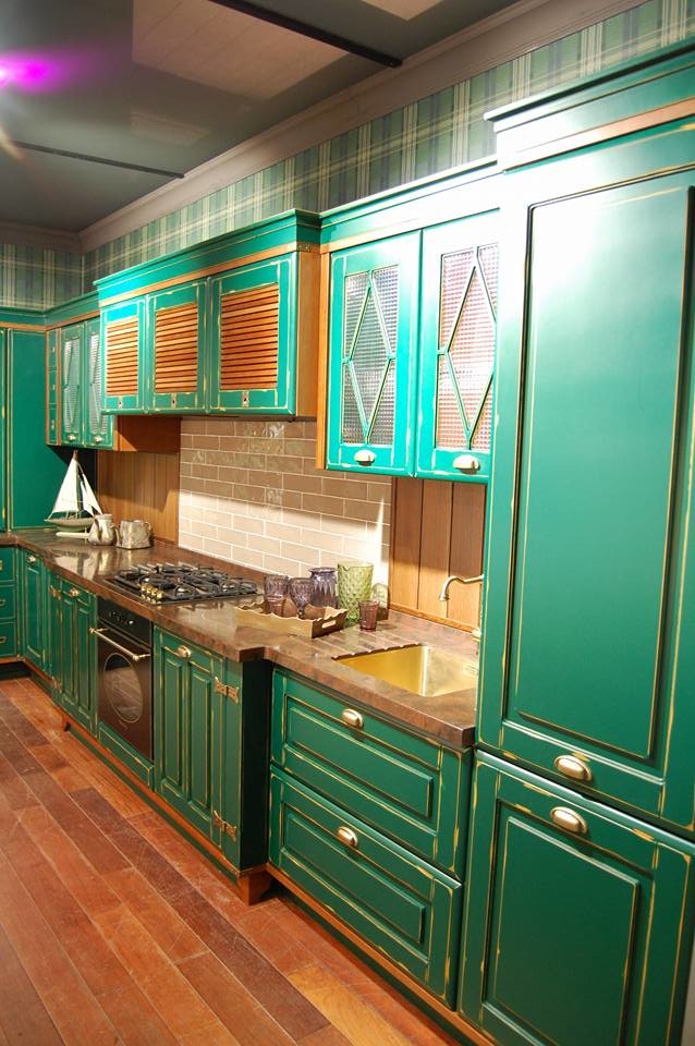 Inredning av ett lantligt mellanstort kök, med luckor med infälld panel, gröna skåp, bänkskiva i koppar, brunt stänkskydd, stänkskydd i trä och färgglada vitvaror