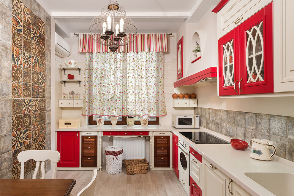 Mid-sized tuscan l-shaped light wood floor eat-in kitchen photo in Other with an integrated sink, beaded inset cabinets, red cabinets, solid surface countertops, brown backsplash, ceramic backsplash, white appliances and no island