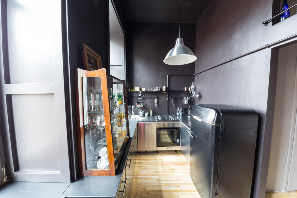 サンクトペテルブルクにある低価格の小さなインダストリアルスタイルのおしゃれなキッチン (アンダーカウンターシンク、ステンレスキャビネット、コンクリートカウンター、黒いキッチンパネル、シルバーの調理設備、無垢フローリング、黒いキッチンカウンター) の写真