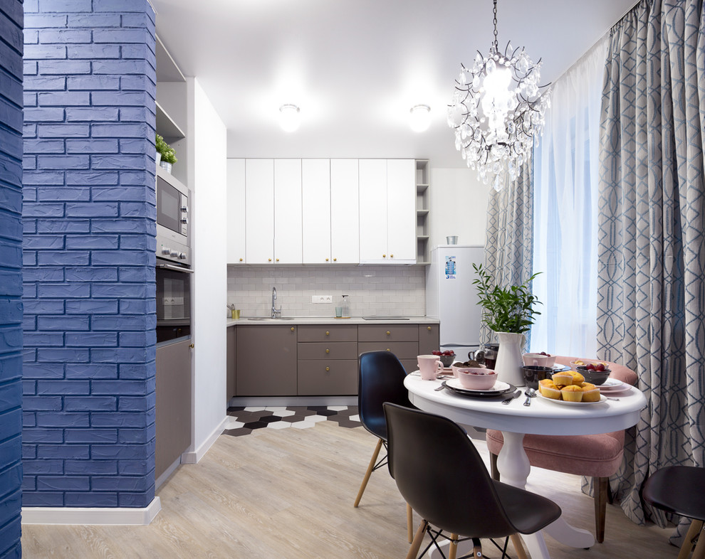 Example of a small trendy l-shaped ceramic tile and multicolored floor eat-in kitchen design in Novosibirsk with an undermount sink, flat-panel cabinets, gray cabinets, laminate countertops, gray backsplash, stainless steel appliances, no island, gray countertops and ceramic backsplash