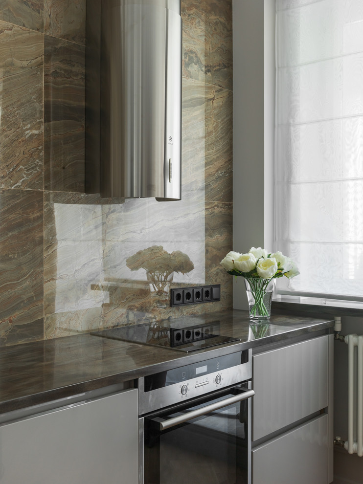 Photo of a classic l-shaped kitchen in Moscow with flat-panel cabinets, grey cabinets, brown splashback and stainless steel appliances.