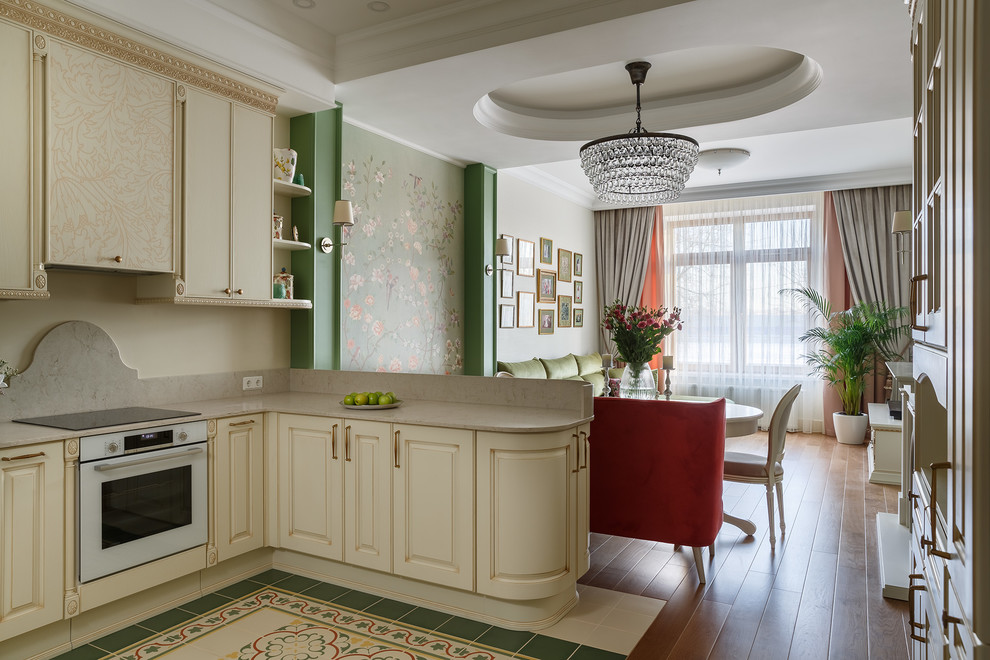 Transitional multicolored floor open concept kitchen photo in Saint Petersburg with raised-panel cabinets, beige cabinets, beige backsplash, white appliances, a peninsula and beige countertops
