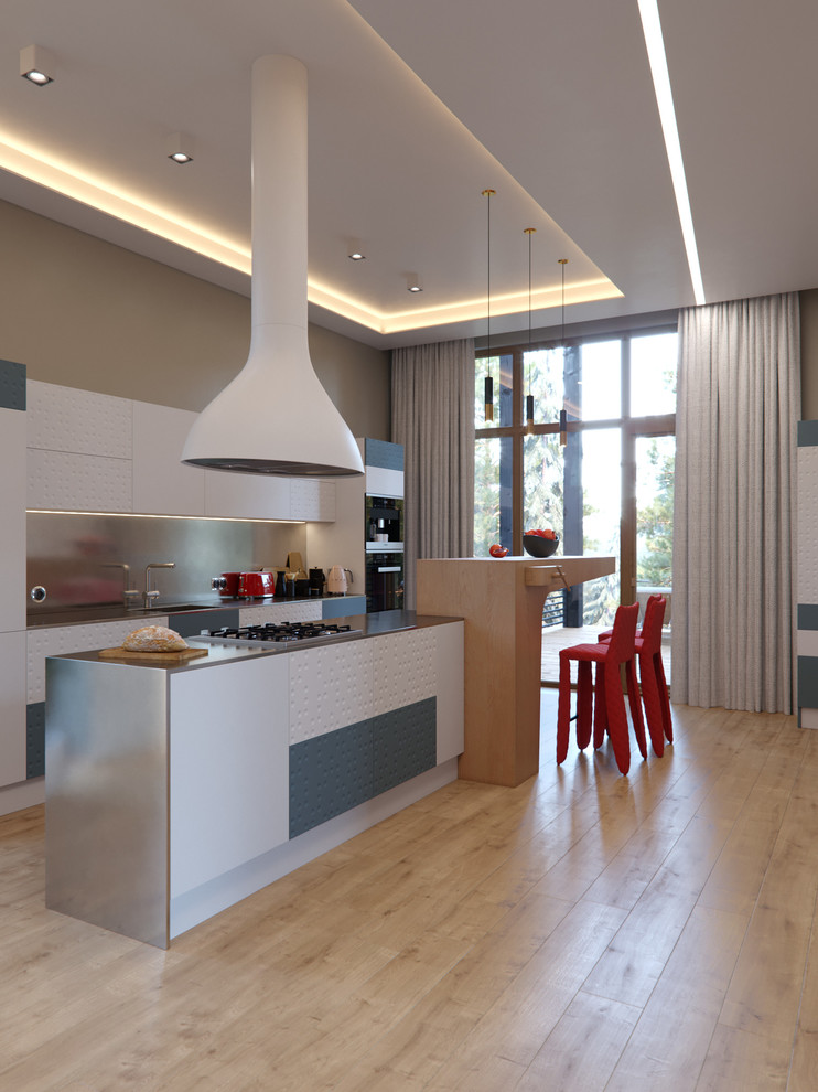 This is an example of a contemporary galley kitchen/diner in Saint Petersburg with a belfast sink, flat-panel cabinets, white cabinets, stainless steel worktops, metallic splashback, stainless steel appliances, light hardwood flooring, an island and beige floors.