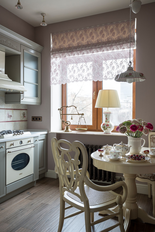 Aménagement d'une petite cuisine victorienne avec un placard avec porte à panneau surélevé, des portes de placard grises, un électroménager blanc et machine à laver.