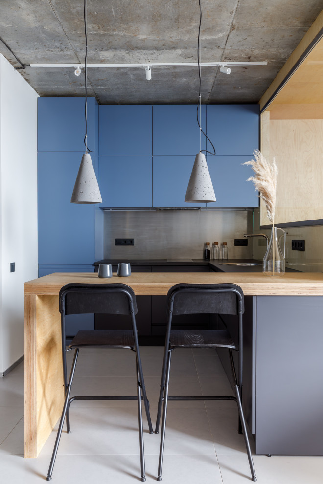 Идея дизайна: п-образная кухня в стиле лофт с плоскими фасадами, синими фасадами, техникой под мебельный фасад, полуостровом, серым полом и черной столешницей