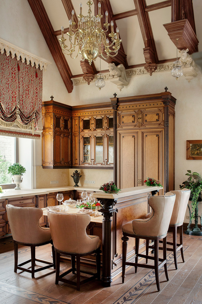 Пример оригинального дизайна: угловая кухня в викторианском стиле с обеденным столом, фасадами с выступающей филенкой, фасадами цвета дерева среднего тона, бежевым фартуком, паркетным полом среднего тона и островом