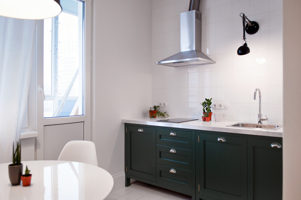 Example of a small danish l-shaped medium tone wood floor enclosed kitchen design in Moscow with an undermount sink, green cabinets, tile countertops, white backsplash, ceramic backsplash and colored appliances