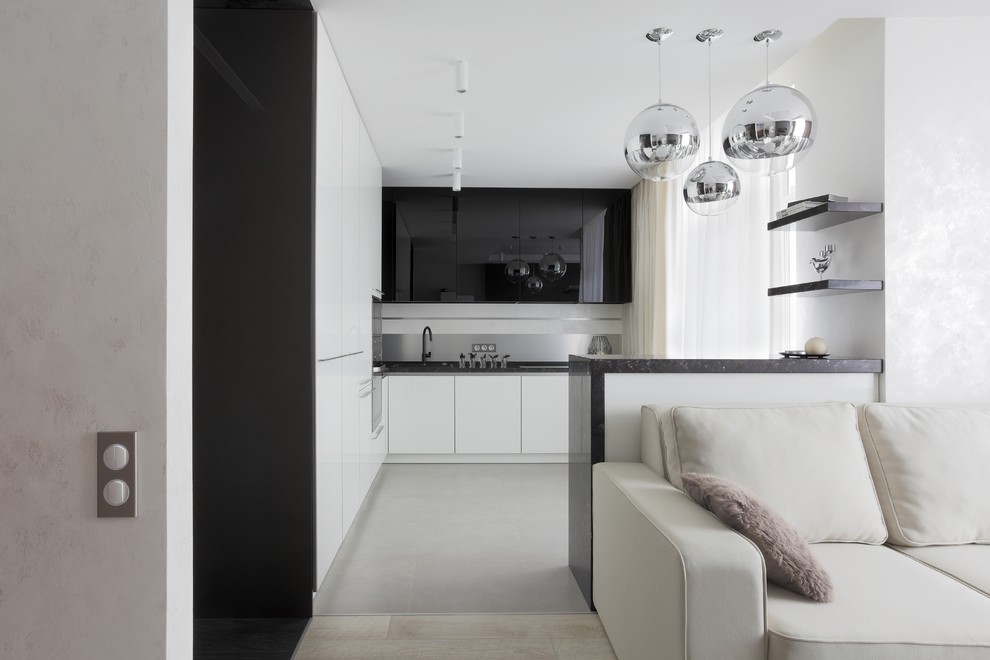 Идея дизайна: угловая кухня-гостиная в современном стиле с плоскими фасадами, белыми фасадами, фартуком цвета металлик и полуостровом