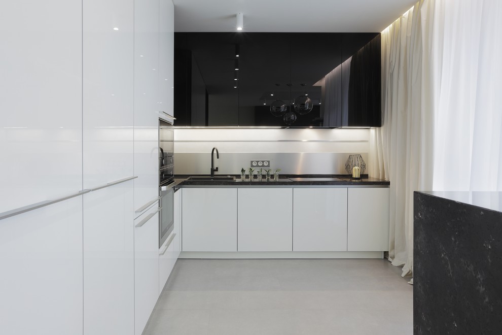 Источник вдохновения для домашнего уюта: угловая кухня-гостиная среднего размера в современном стиле с плоскими фасадами, белыми фасадами и серым фартуком без острова