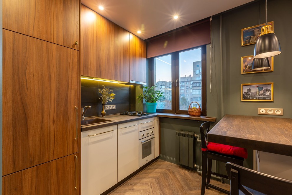Photo of a small scandinavian single-wall open plan kitchen in Moscow with a built-in sink, flat-panel cabinets, black splashback, porcelain splashback, white appliances, vinyl flooring, an island, brown floors and brown worktops.