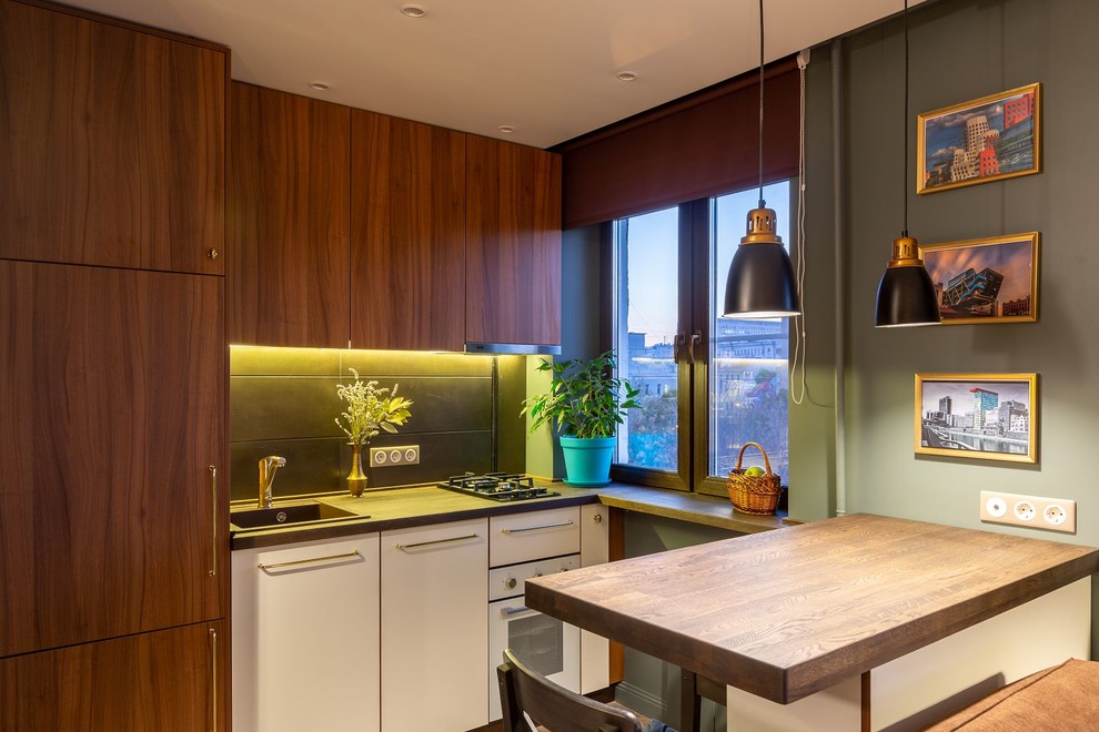 This is an example of a small scandi single-wall open plan kitchen in Moscow with a built-in sink, flat-panel cabinets, black splashback, porcelain splashback, white appliances, vinyl flooring, an island, brown floors and brown worktops.