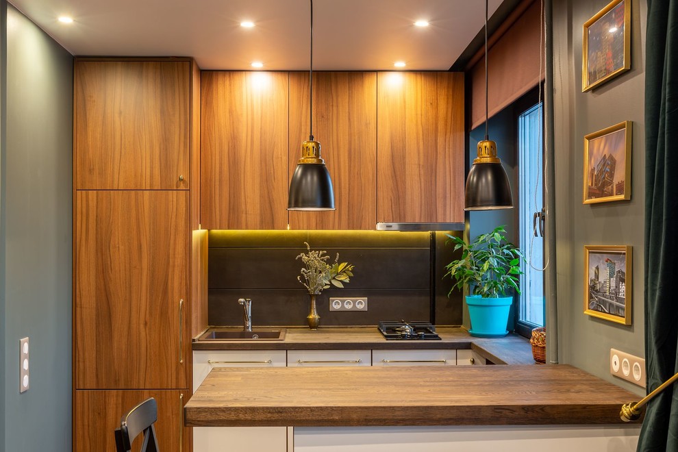 Idéer för ett litet minimalistiskt brun linjärt kök med öppen planlösning, med en nedsänkt diskho, släta luckor, svart stänkskydd, stänkskydd i porslinskakel, vita vitvaror, vinylgolv, en köksö och brunt golv