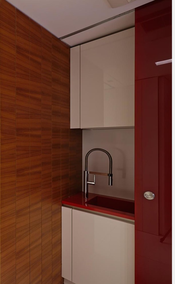 Modelo de cocina lineal contemporánea pequeña con fregadero integrado, armarios con paneles lisos, encimera de cuarcita, salpicadero blanco, salpicadero de vidrio templado, suelo de mármol, suelo blanco y encimeras rojas