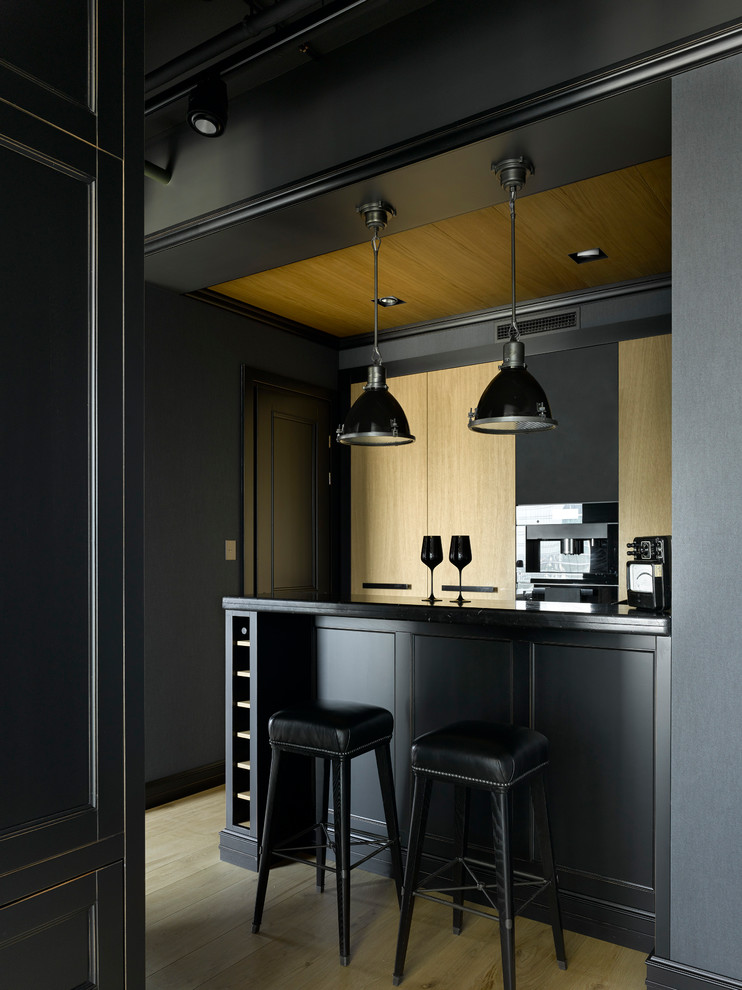 На фото: кухня в классическом стиле с светлым паркетным полом, полуостровом, бежевым полом и черной столешницей с