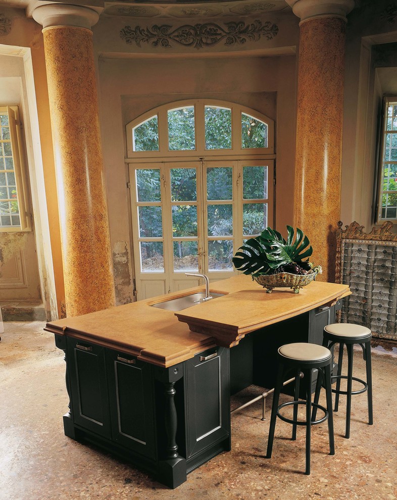 Klassisk inredning av ett stort linjärt kök och matrum, med svarta vitvaror, marmorgolv, en köksö, en undermonterad diskho, svarta skåp och bänkskiva i kvarts