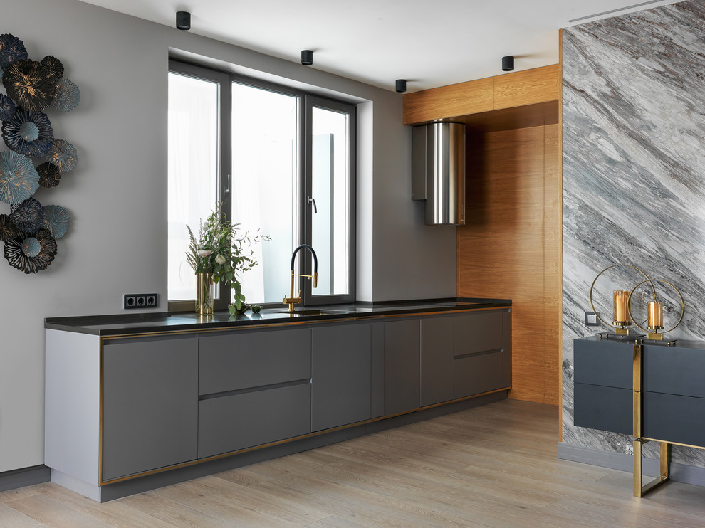 Esempio di una cucina lineare contemporanea con ante in legno scuro, paraspruzzi grigio, parquet chiaro, nessuna isola, pavimento beige e top nero