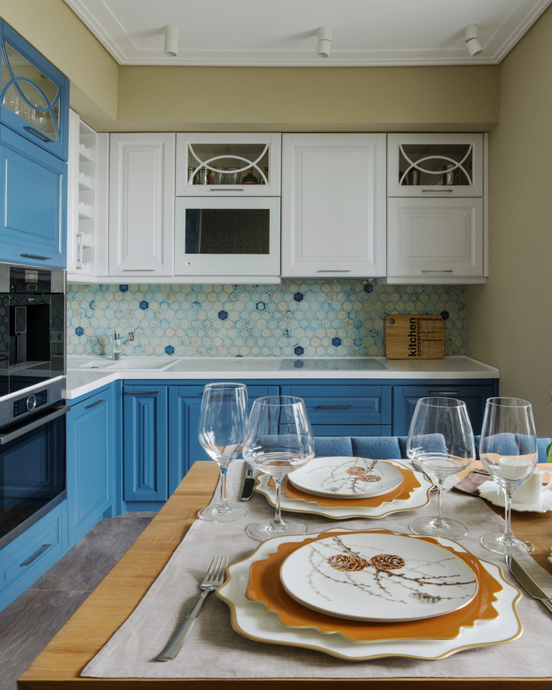 モスクワにあるコンテンポラリースタイルのおしゃれなキッチン (ドロップインシンク、レイズドパネル扉のキャビネット、青いキャビネット、青いキッチンパネル、シルバーの調理設備、アイランドなし、グレーの床、白いキッチンカウンター) の写真