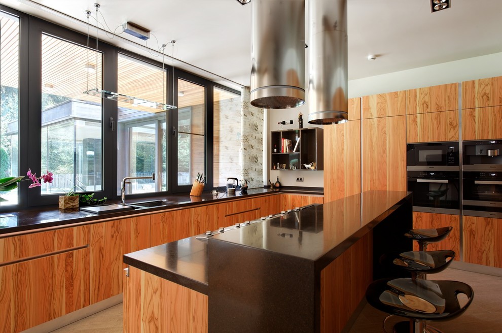 Idée de décoration pour une cuisine design en bois brun avec un évier posé, un placard à porte plane, fenêtre, un électroménager en acier inoxydable et îlot.