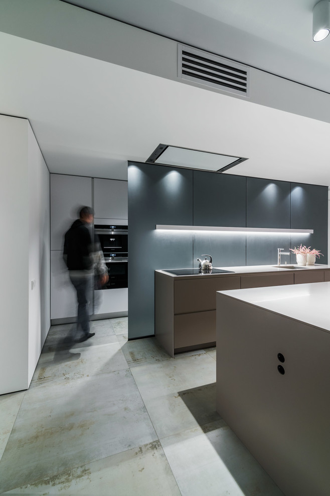 This is an example of a medium sized contemporary galley kitchen/diner in Other with a submerged sink, flat-panel cabinets, beige cabinets, composite countertops, grey splashback, glass tiled splashback, stainless steel appliances, ceramic flooring and multiple islands.