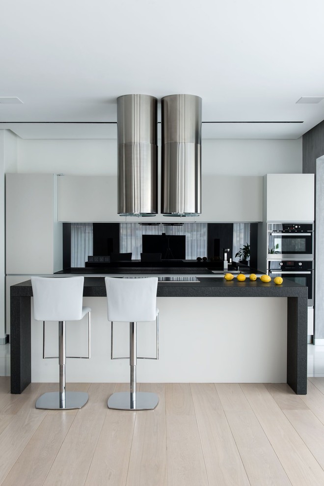 Idéer för ett mellanstort modernt linjärt kök, med vita skåp, marmorbänkskiva, svart stänkskydd och flera köksöar