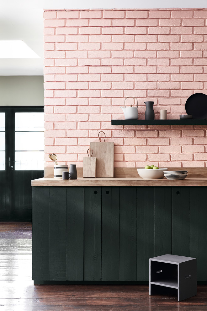 Immagine di una cucina bohémian con ante lisce, ante nere, top in legno, paraspruzzi rosa, paraspruzzi in mattoni, parquet scuro e pavimento marrone