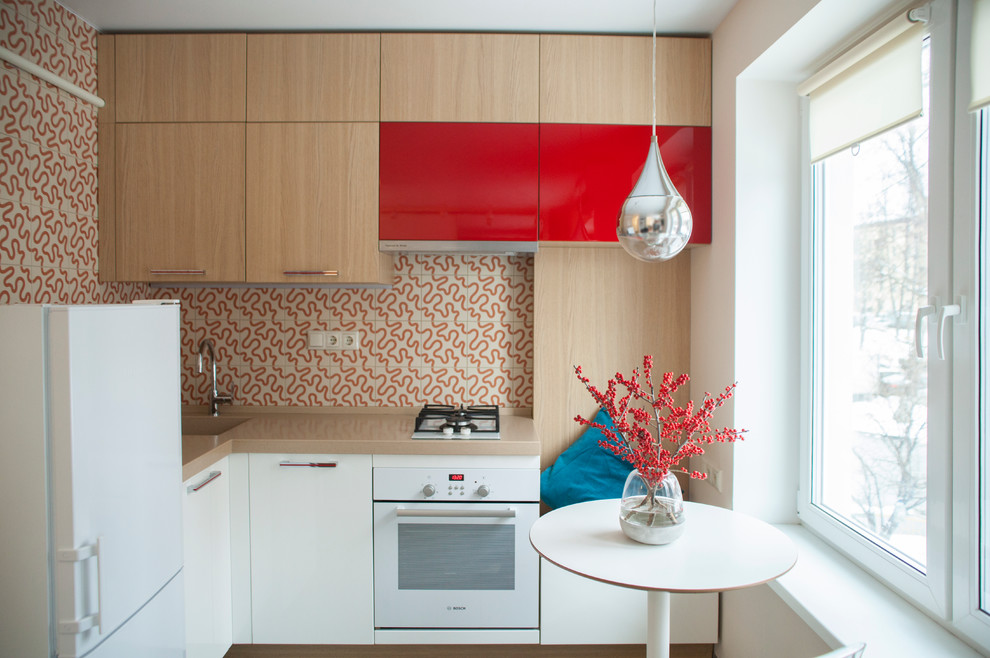 Пример оригинального дизайна: угловая кухня-гостиная в современном стиле с монолитной мойкой, плоскими фасадами, разноцветным фартуком, белой техникой и мойкой в углу без острова