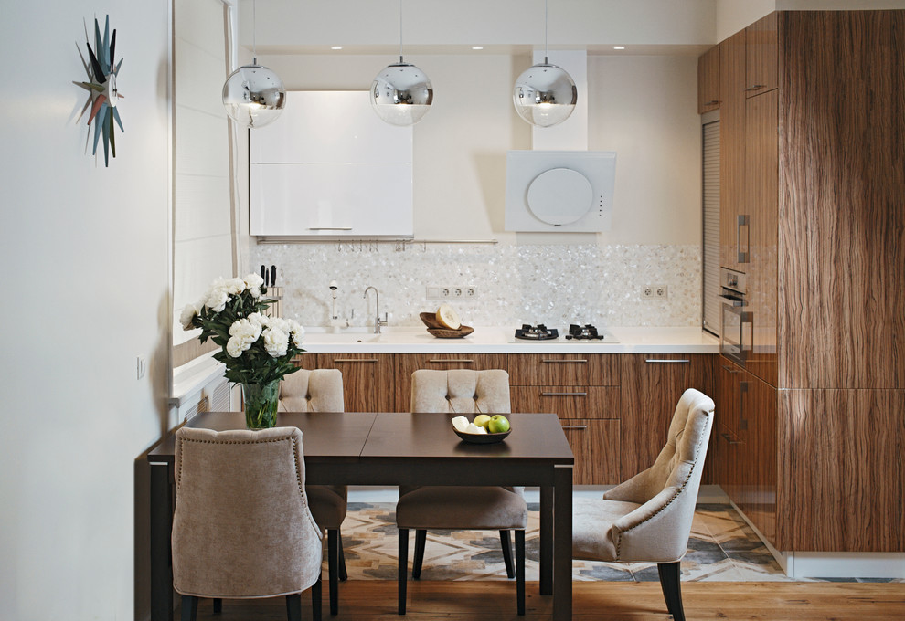 Bild på ett funkis kök, med en integrerad diskho, släta luckor, skåp i mellenmörkt trä, vitt stänkskydd och rostfria vitvaror