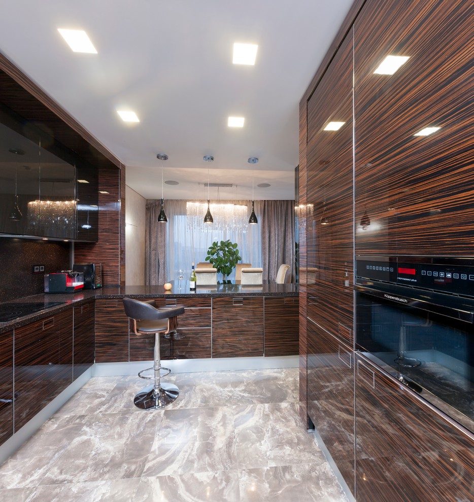 Ejemplo de cocina actual con armarios con paneles lisos, puertas de armario de madera en tonos medios y electrodomésticos negros
