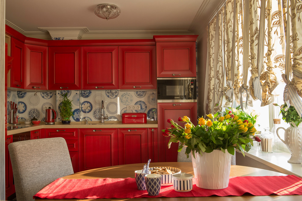 Источник вдохновения для домашнего уюта: кухня в стиле неоклассика (современная классика) с красными фасадами, разноцветным фартуком и техникой из нержавеющей стали