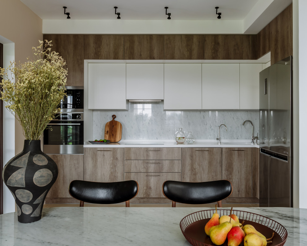 Design ideas for a contemporary l-shaped kitchen/diner in Moscow with flat-panel cabinets, medium wood cabinets, grey splashback, stone slab splashback, stainless steel appliances, no island and white worktops.