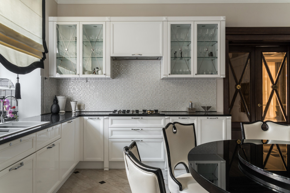 Kitchen - transitional l-shaped beige floor kitchen idea in Moscow with a drop-in sink, recessed-panel cabinets, white cabinets, white backsplash, mosaic tile backsplash and black countertops