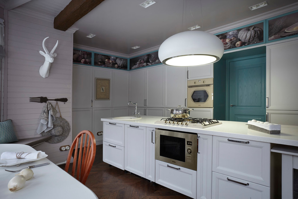 Пример оригинального дизайна: угловая кухня в скандинавском стиле с обеденным столом, накладной мойкой, фасадами с утопленной филенкой, белыми фасадами, техникой из нержавеющей стали и островом