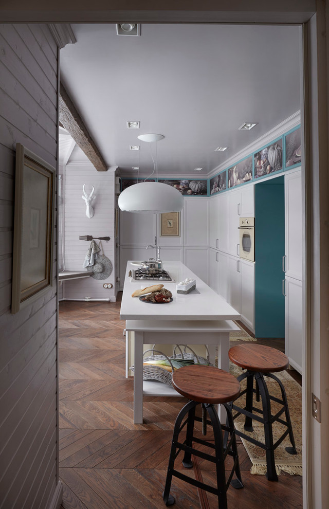 Стильный дизайн: угловая кухня в скандинавском стиле с обеденным столом, накладной мойкой, фасадами с утопленной филенкой, белыми фасадами, островом, белой техникой и паркетным полом среднего тона - последний тренд