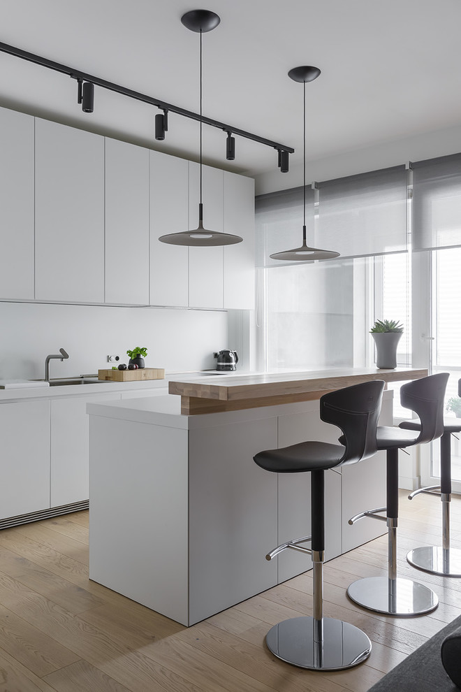 Inspiration for a medium sized contemporary kitchen with a single-bowl sink, white cabinets, white splashback, an island, beige floors, flat-panel cabinets and white worktops.