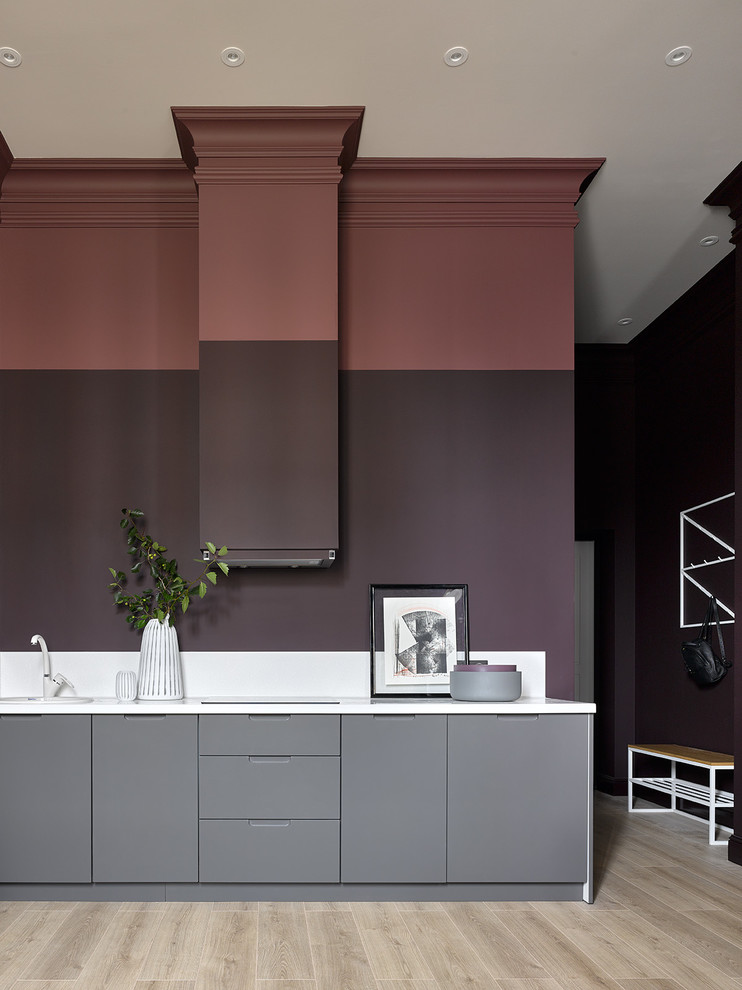 Ejemplo de cocina lineal contemporánea con armarios con paneles lisos, puertas de armario grises, suelo beige y encimeras blancas
