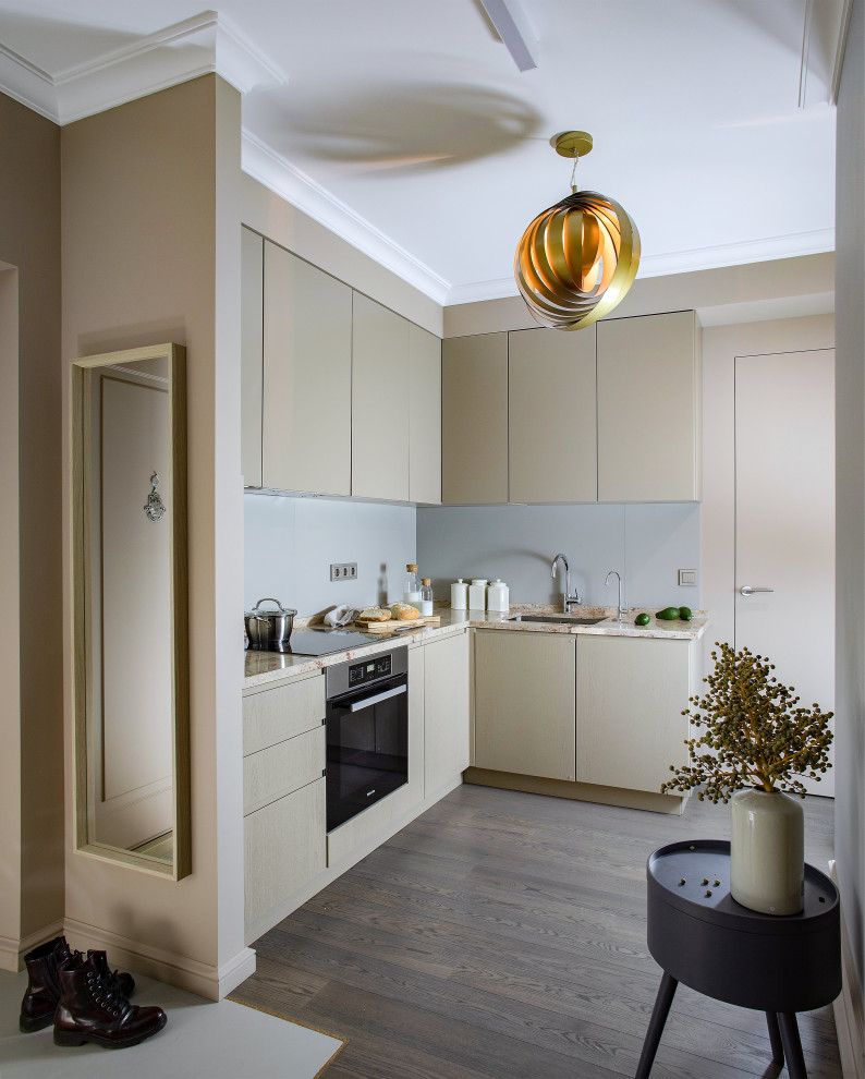 Example of a trendy l-shaped medium tone wood floor and brown floor kitchen design in Moscow with an undermount sink, flat-panel cabinets, beige cabinets, stainless steel appliances, no island and beige countertops
