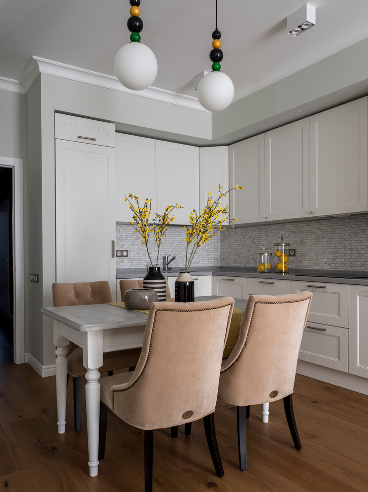Transitional l-shaped medium tone wood floor and brown floor eat-in kitchen photo in Moscow with recessed-panel cabinets, white cabinets, gray backsplash, mosaic tile backsplash, no island and gray countertops