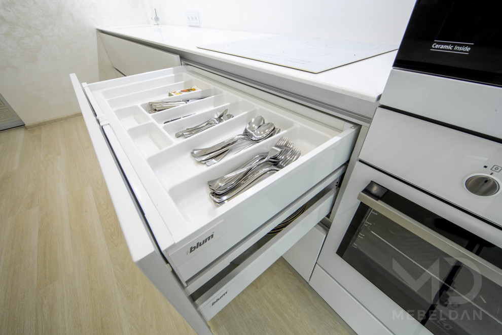 Foto de cocina comedor lineal, contemporánea, de tamaño medio, sin isla, con fregadero bajoencimera, armarios con paneles lisos, puertas de armario blancas, encimera de acrílico, salpicadero blanco, electrodomésticos blancos, suelo beige y encimeras blancas