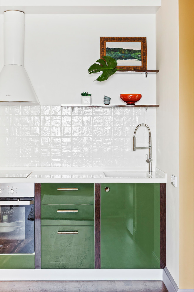 Bild på ett litet vintage vit linjärt vitt kök med öppen planlösning, med en integrerad diskho, släta luckor, gröna skåp, bänkskiva i koppar, vitt stänkskydd, stänkskydd i keramik, mellanmörkt trägolv, brunt golv och rostfria vitvaror
