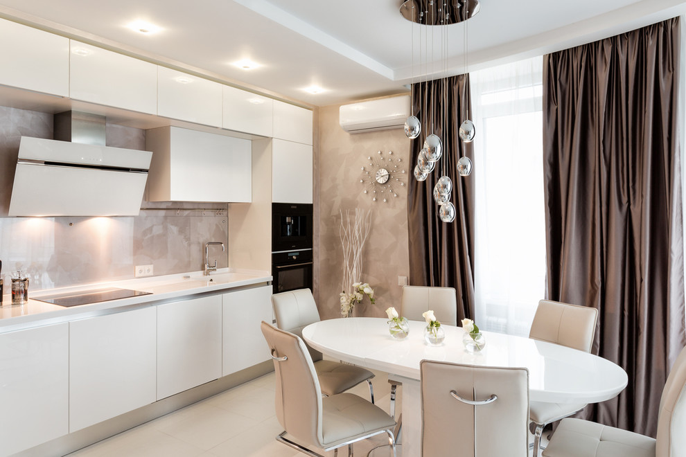 Eat-in kitchen - contemporary single-wall eat-in kitchen idea in Other with an integrated sink, flat-panel cabinets, white cabinets, beige backsplash, stone tile backsplash, black appliances and no island