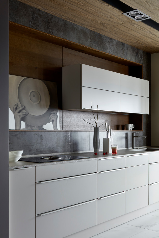 Diseño de cocina contemporánea con armarios con paneles lisos, salpicadero verde, suelo blanco, encimeras grises, fregadero de un seno y puertas de armario grises