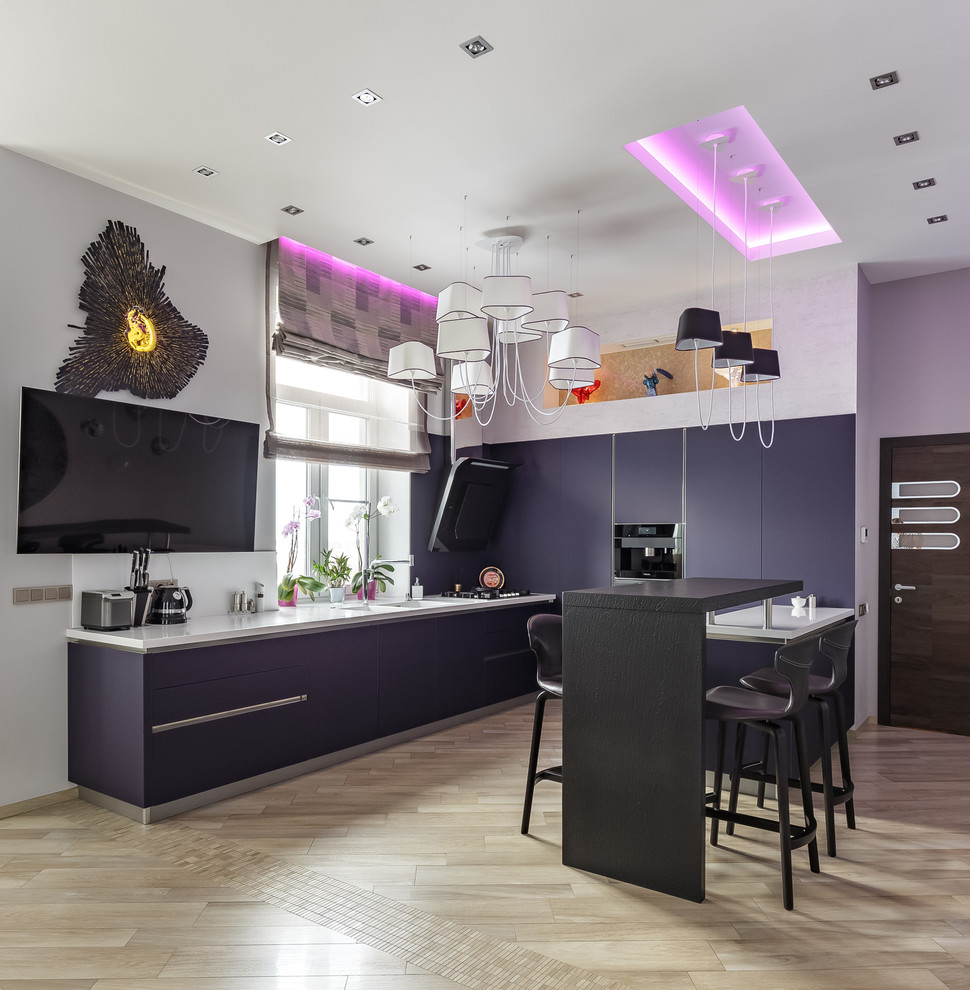 Exemple d'une cuisine ouverte tendance en U avec un placard à porte plane, des portes de placard violettes, îlot, un évier intégré, une crédence blanche, un électroménager noir, un sol beige et un plan de travail blanc.