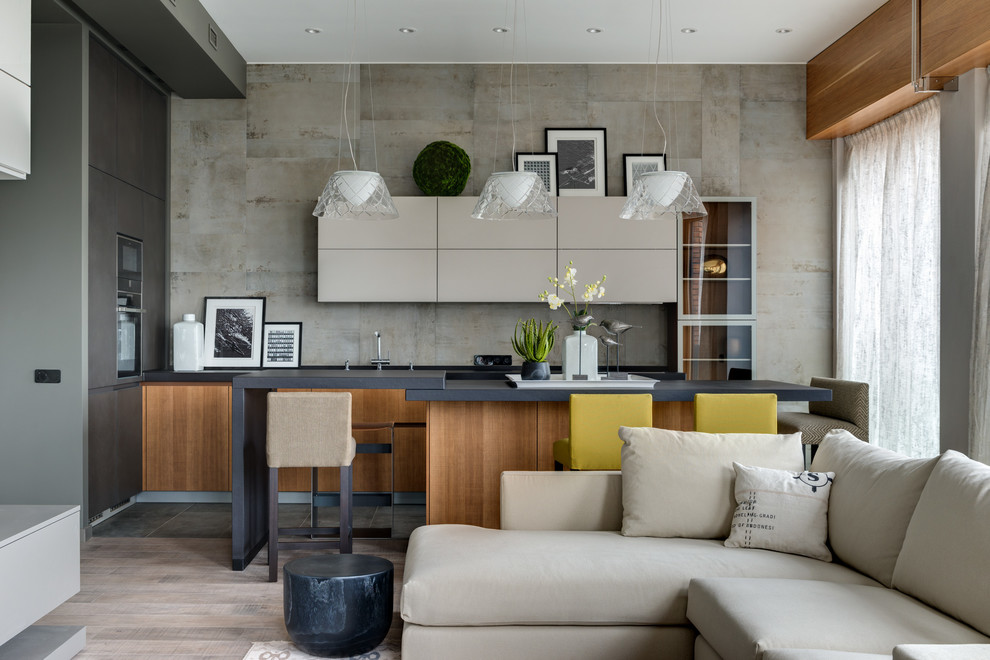 This is an example of a contemporary galley open plan kitchen in Moscow with flat-panel cabinets, grey splashback, an island and medium wood cabinets.