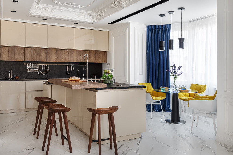 Design ideas for a contemporary kitchen/diner in Moscow with flat-panel cabinets, beige cabinets, black splashback, stone slab splashback, an island, white floors and black worktops.