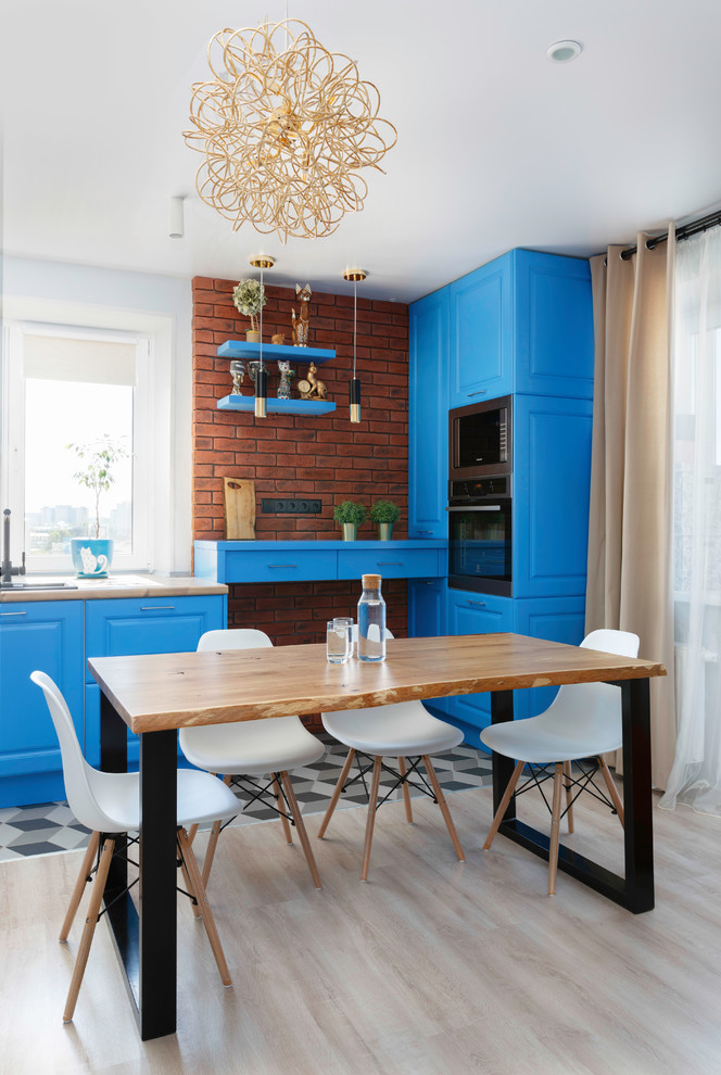 Immagine di una cucina contemporanea con lavello da incasso, ante con bugna sagomata, ante blu, paraspruzzi marrone, paraspruzzi in mattoni, elettrodomestici neri e nessuna isola