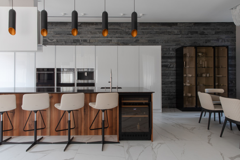 Inspiration for a contemporary white floor open concept kitchen remodel in Other with an island and black countertops