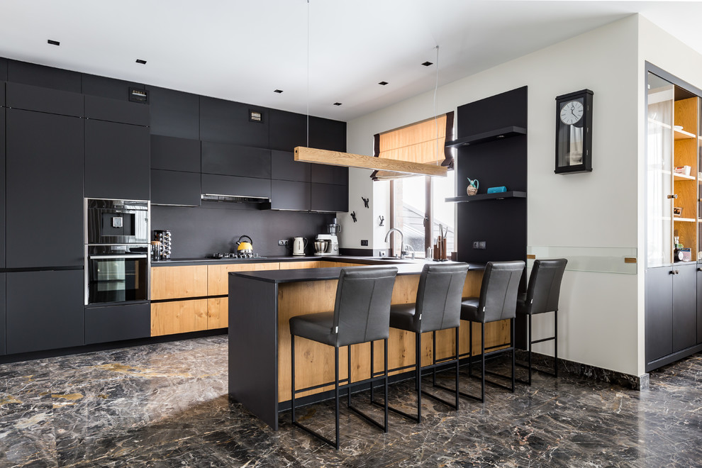 This is an example of a large contemporary l-shaped kitchen/diner in Saint Petersburg with flat-panel cabinets, composite countertops, black splashback, stone slab splashback, black appliances, porcelain flooring, a breakfast bar, brown floors, black worktops and black cabinets.