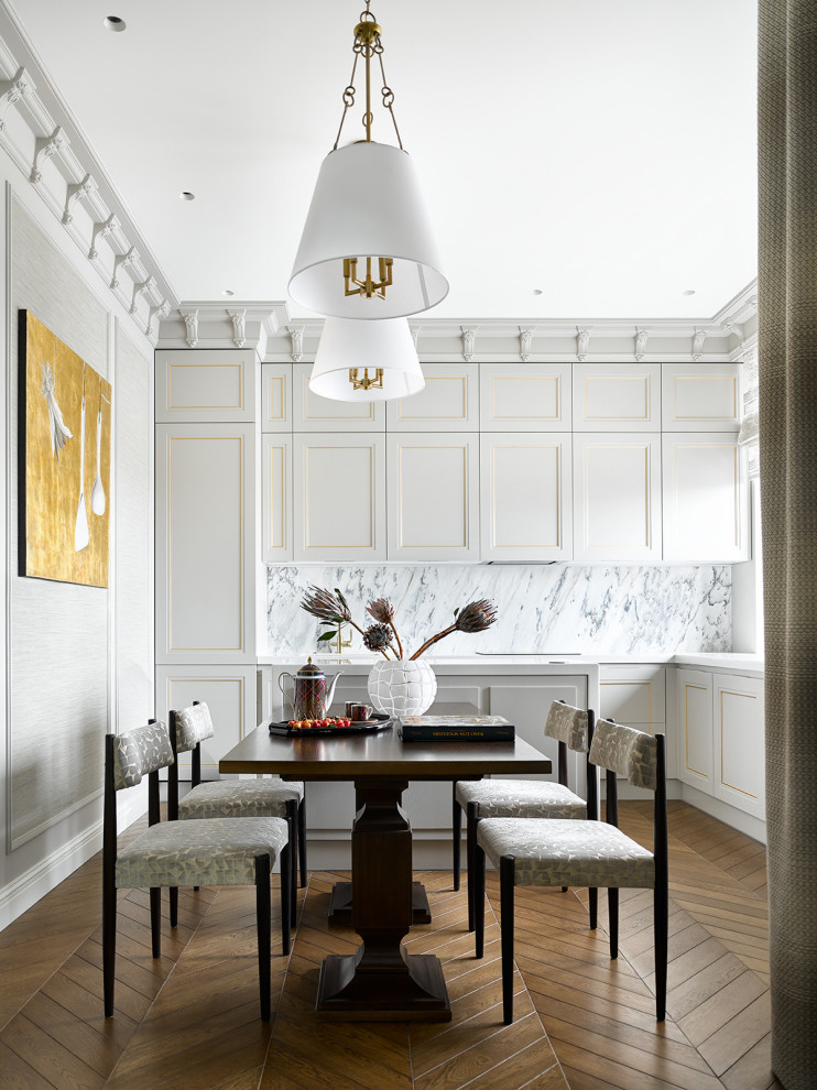 Inspiration för klassiska vitt l-kök, med luckor med infälld panel, vita skåp, vitt stänkskydd, en köksö och brunt golv