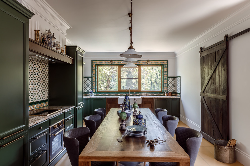 Medelhavsstil inredning av ett kök och matrum, med en rustik diskho, luckor med infälld panel, gröna skåp och beiget golv